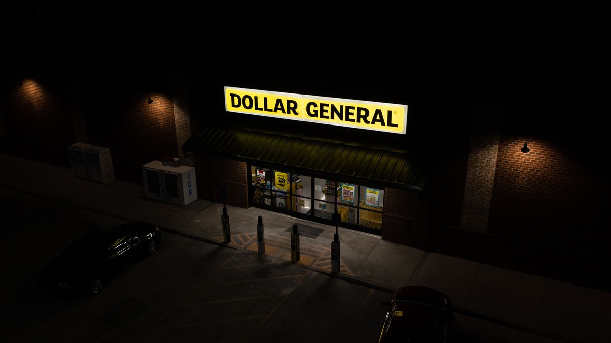 A Dollar General storefront at nighttime featuring the company's signature yellow and black sign
