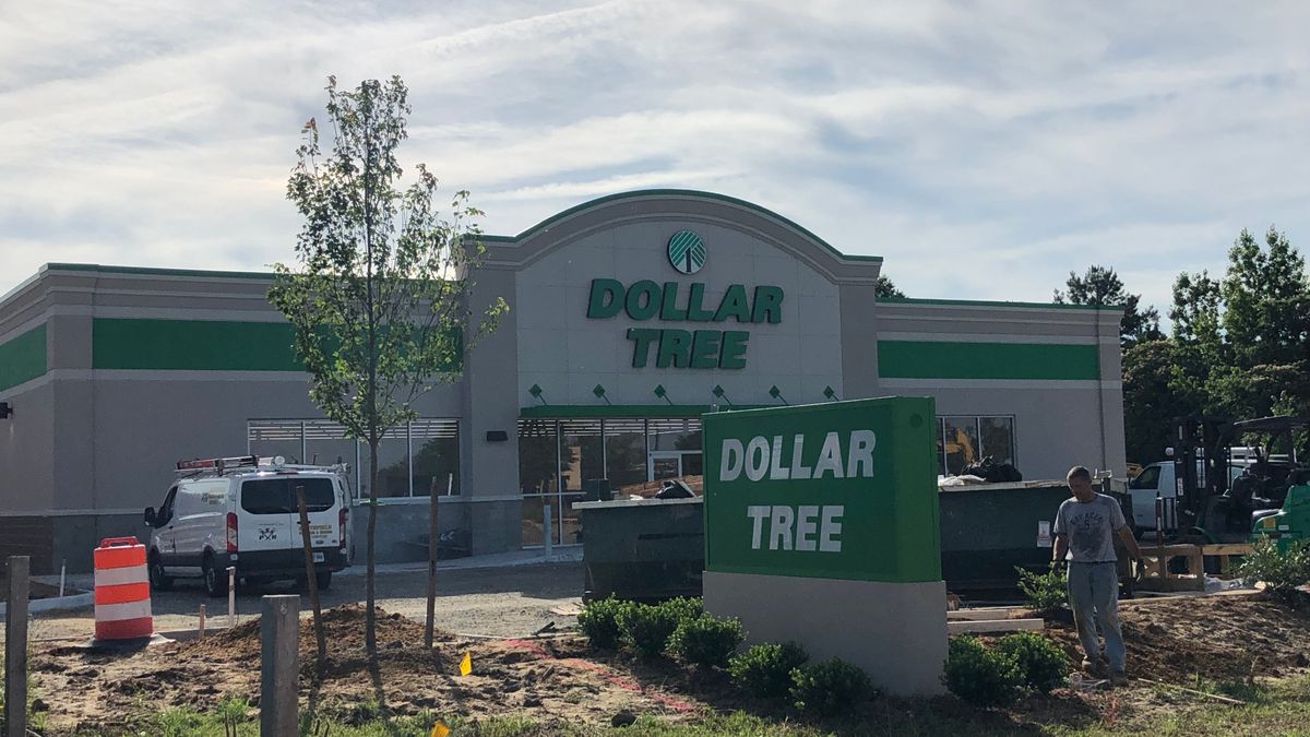 The exterior of a newly constructed Dollar Tree store with the company's signature green color scheme with a blue sky