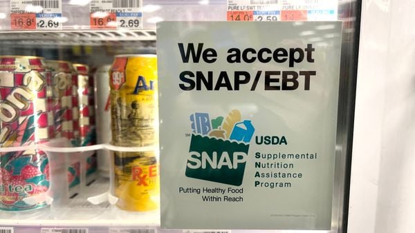 A sign on a drinks case door that reads "We accept SNAP/EBT."